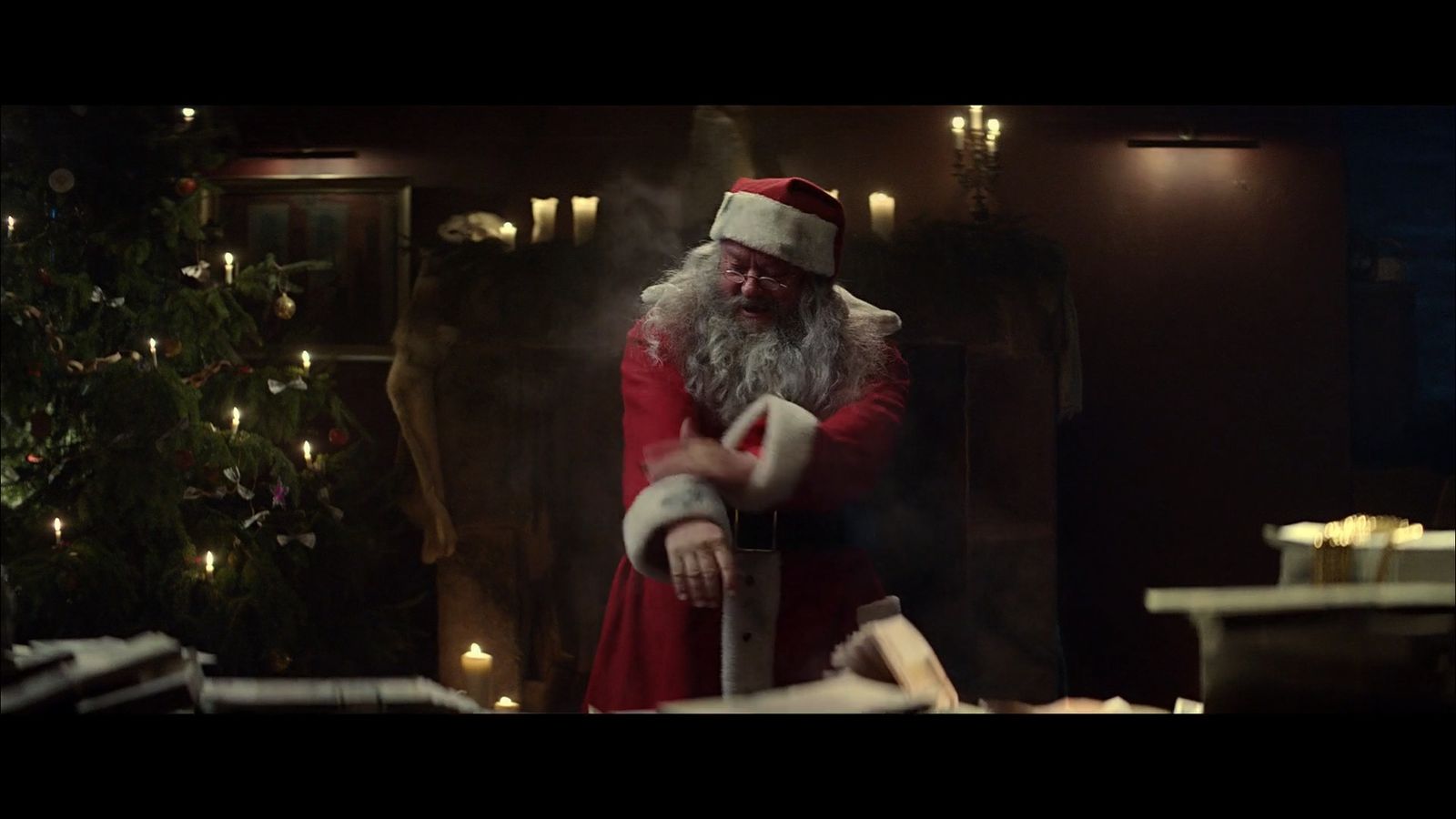 a man dressed as santa claus holding a knife