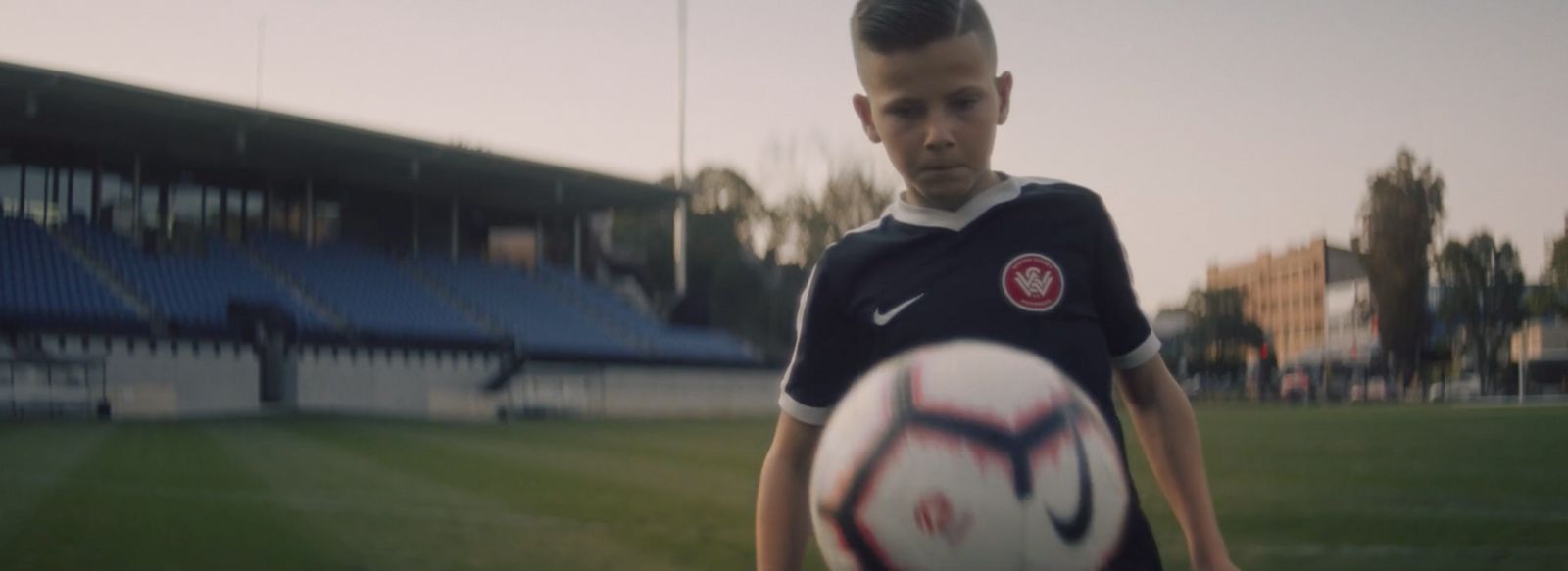 a young boy holding a soccer ball on a field