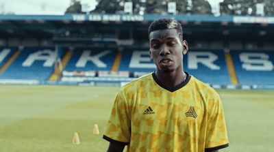 a man standing on a soccer field wearing a yellow shirt