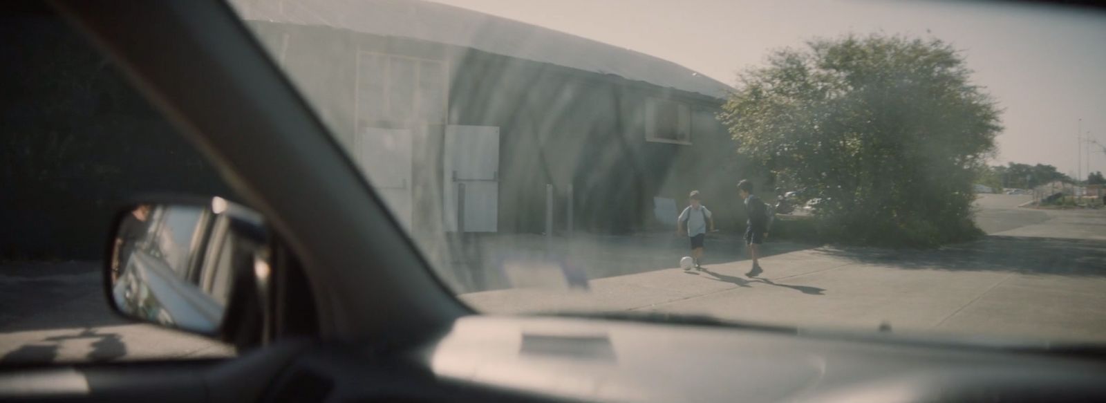 a couple of people walking down a street next to a building