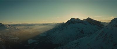 the sun shines through the clouds over the mountains