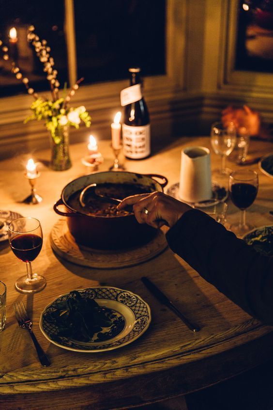 a person sitting at a table with food and wine