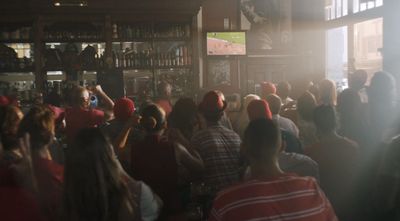 a crowd of people standing around a bar