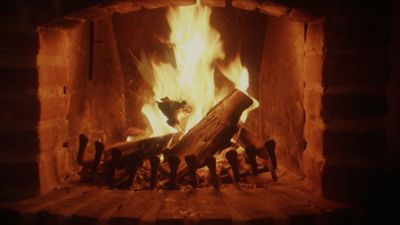 a fire burning in a fireplace with logs