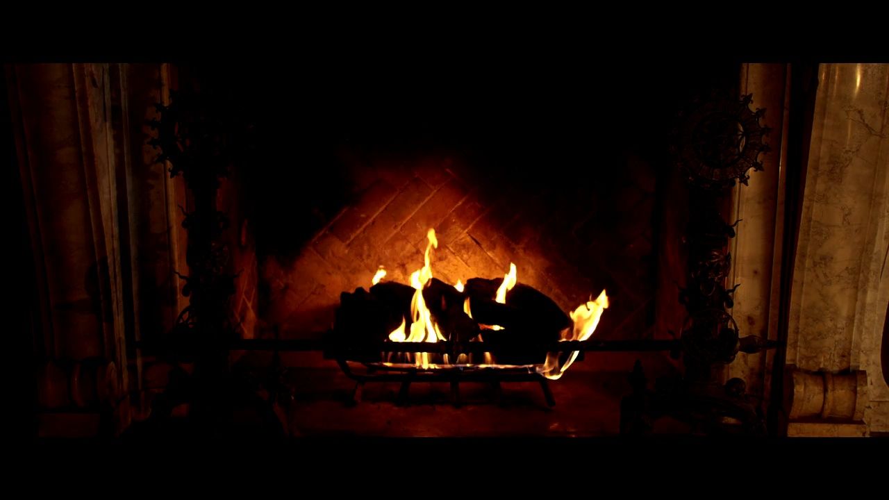 a fire burning in a fireplace in a dark room