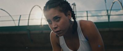 a woman in a white tank top holding a tennis racquet