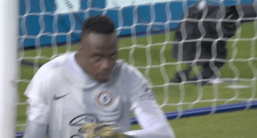 a soccer player standing in front of a goal