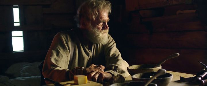 a man with a beard sitting at a table