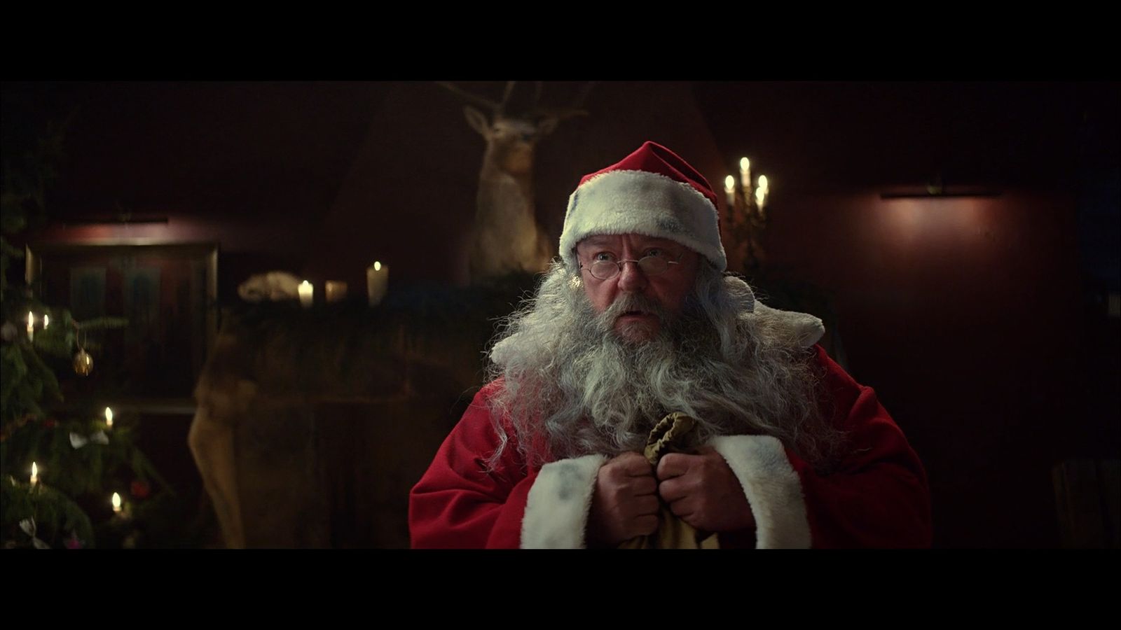 a man dressed as santa claus holding a bell