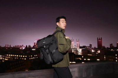 a man with a backpack standing on a roof