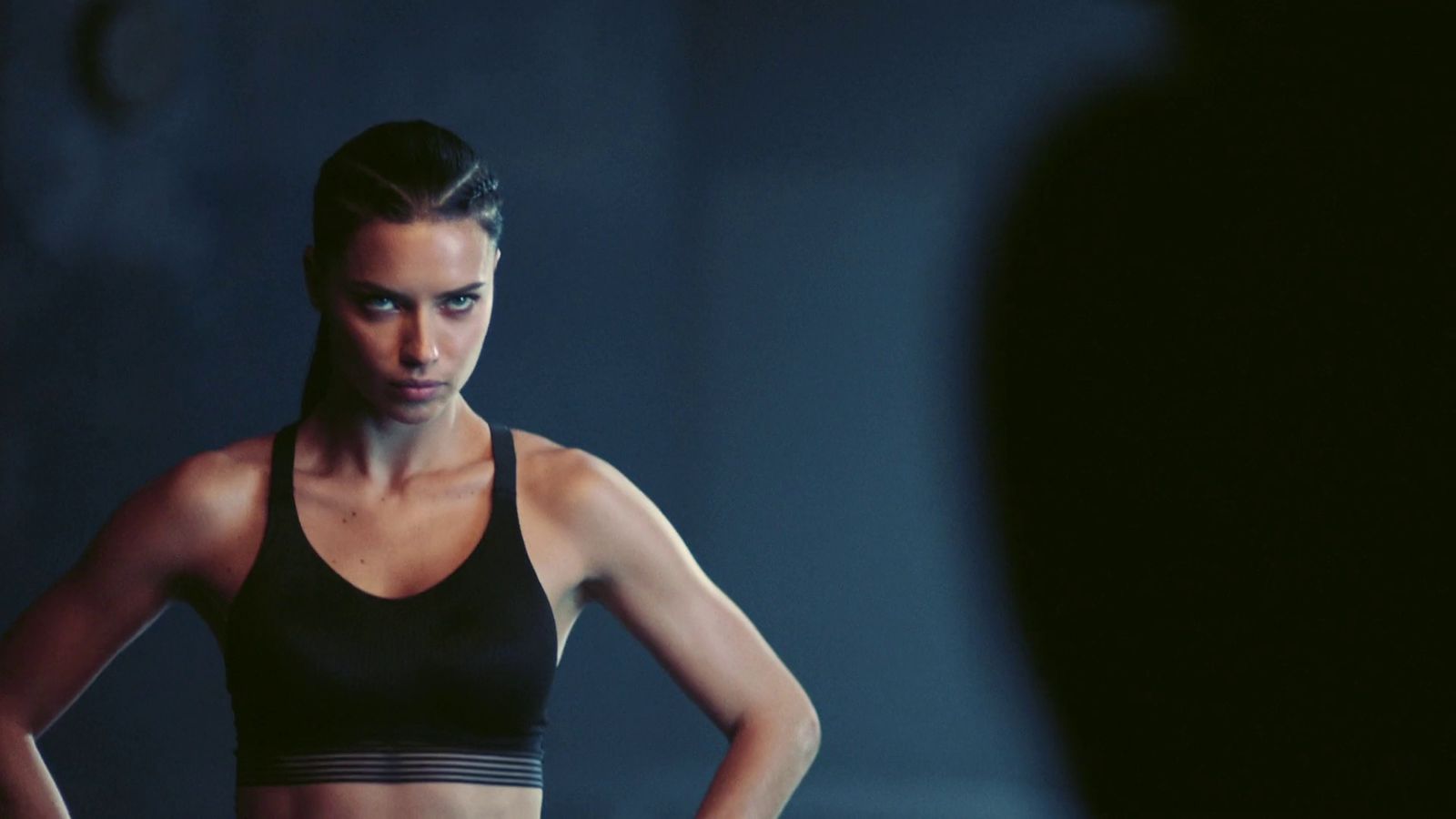 a woman in a black sports bra looking at her reflection