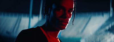 a man with dreadlocks standing in a dark room