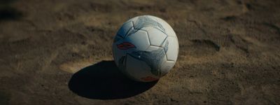 a white soccer ball sitting on top of a sandy field