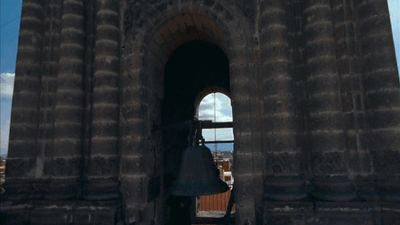 a bell on a tower with a sky in the background