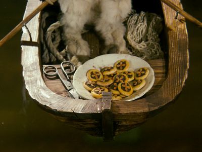 a dog sitting in a boat with a plate of food