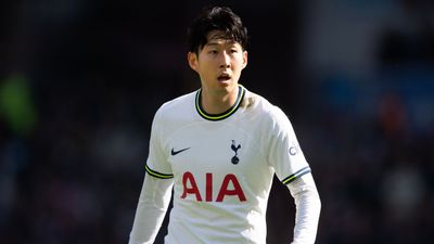 a young man in a white shirt is playing soccer