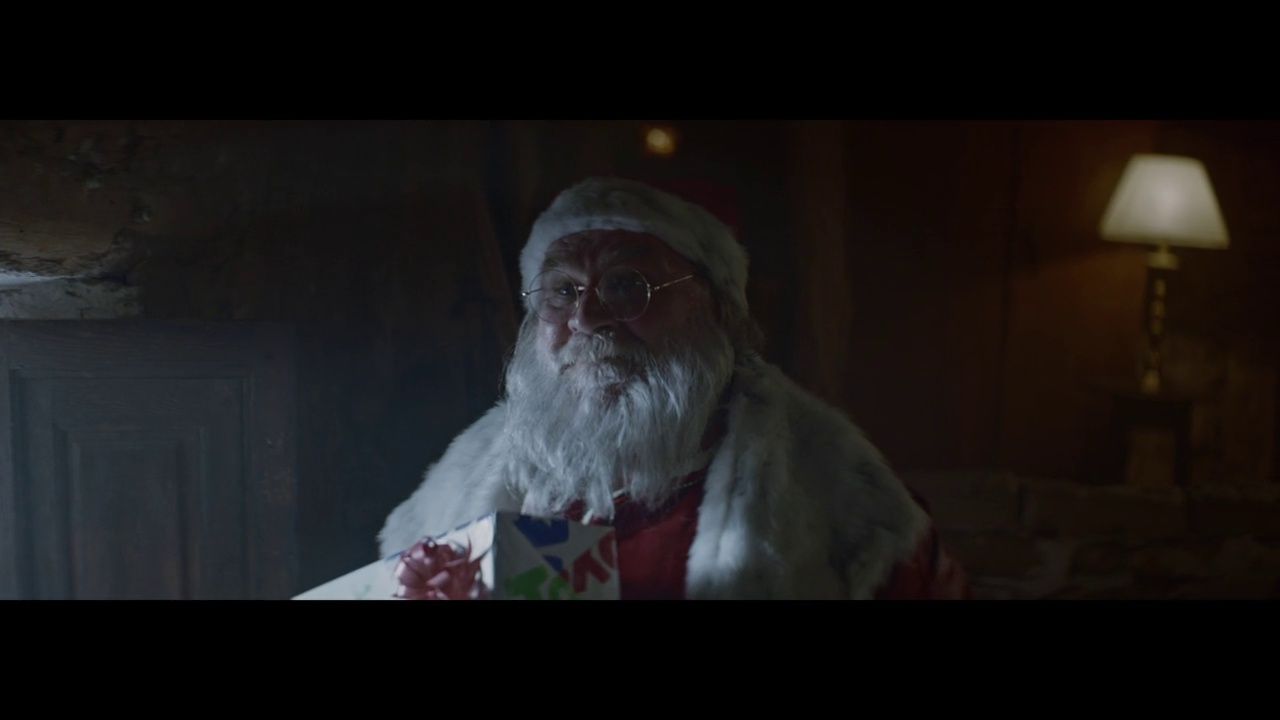 a man dressed as santa claus in a dark room