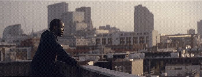 a man standing on top of a roof next to a city