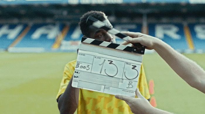 a man holding a movie clapper in front of his face