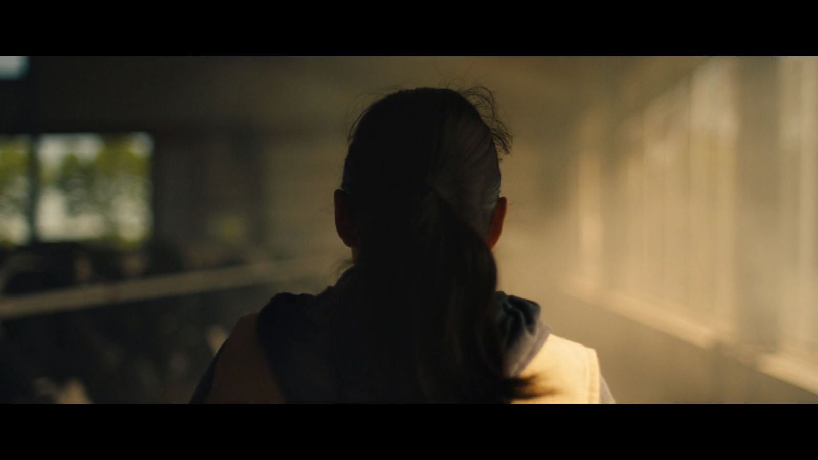 a woman looking out a window in a dark room