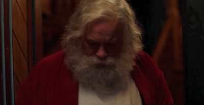 a man with a long white beard wearing a red cardigan