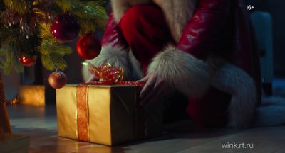 a person in a santa suit opening a gift box