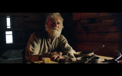 an old man sitting at a table with a plate of food