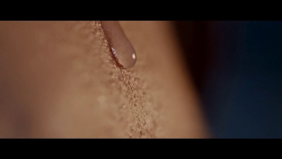 a drop of water on the side of a woman's breast