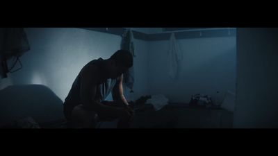 a man sitting on a bed in a dark room