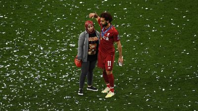 a couple of people standing on top of a soccer field