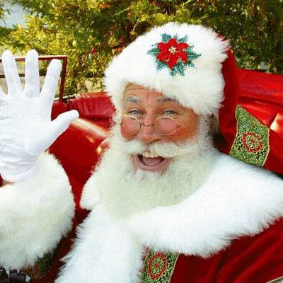 a man dressed as santa claus waves to the crowd