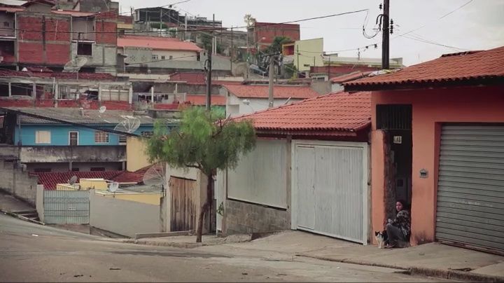 a man sitting on the side of a road next to a building