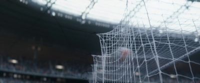 a blurry photo of a soccer goal in a stadium