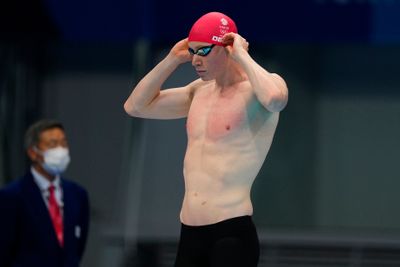 a man wearing a red hat and swimming trunks