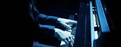 a person playing a piano in a dark room