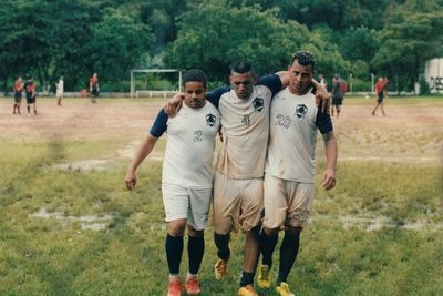 a group of men standing on top of a lush green field