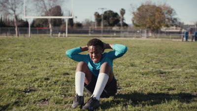 a man sitting on the ground in a soccer field