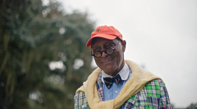 an older man wearing a red hat and glasses