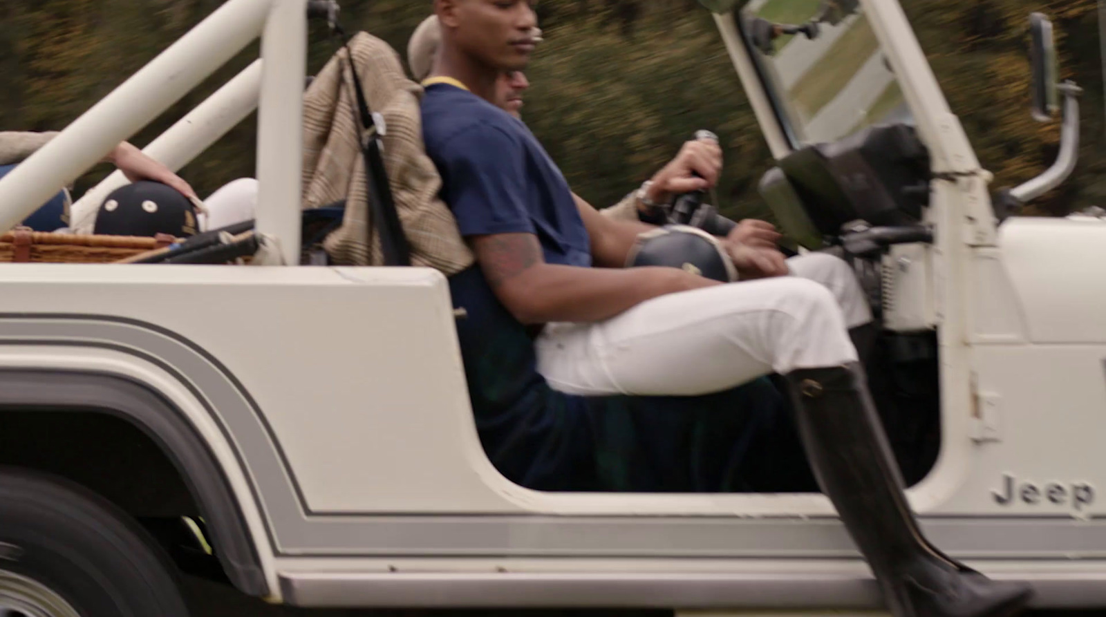 a man riding in the back of a white jeep