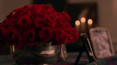 a bunch of red roses in a silver vase