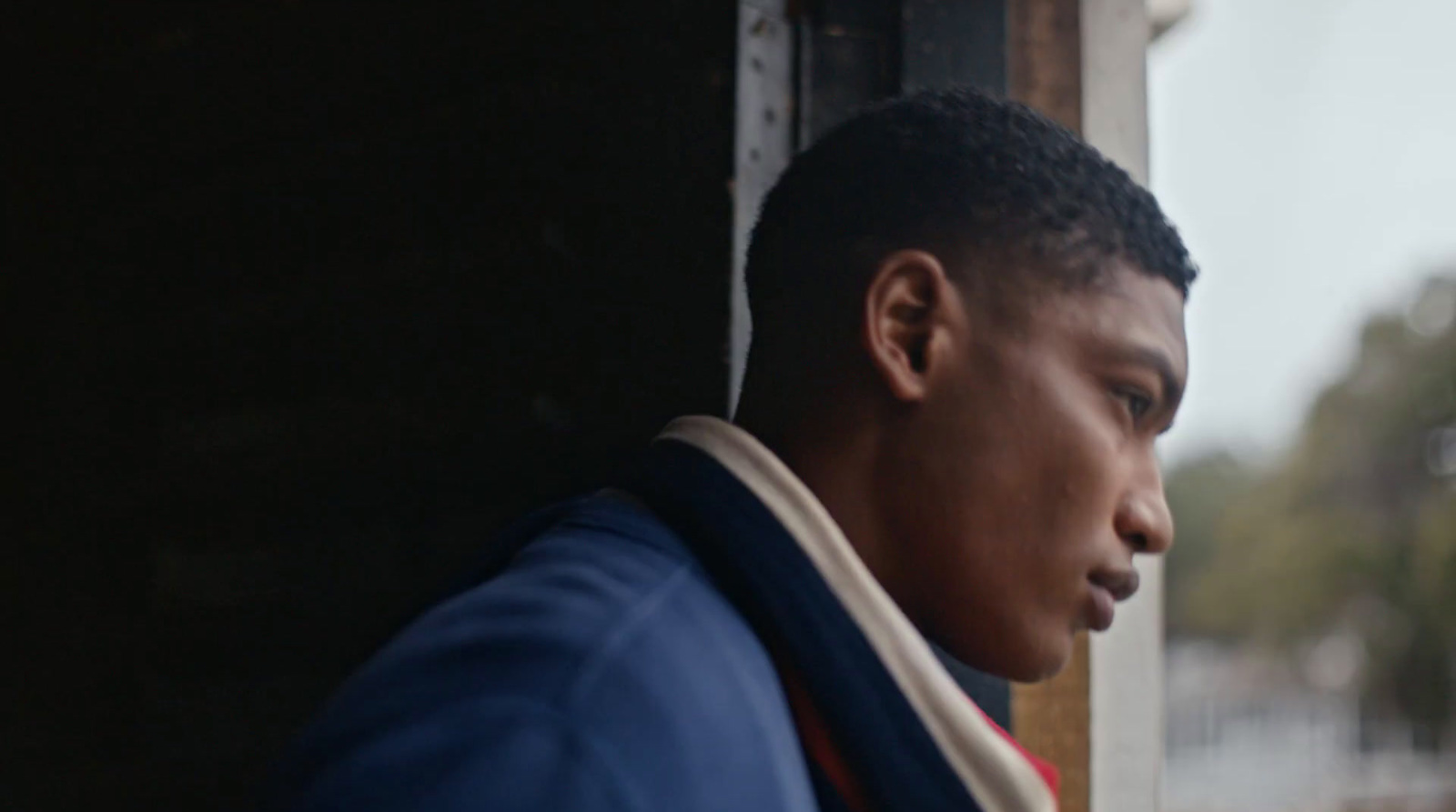 a close up of a person leaning against a wall