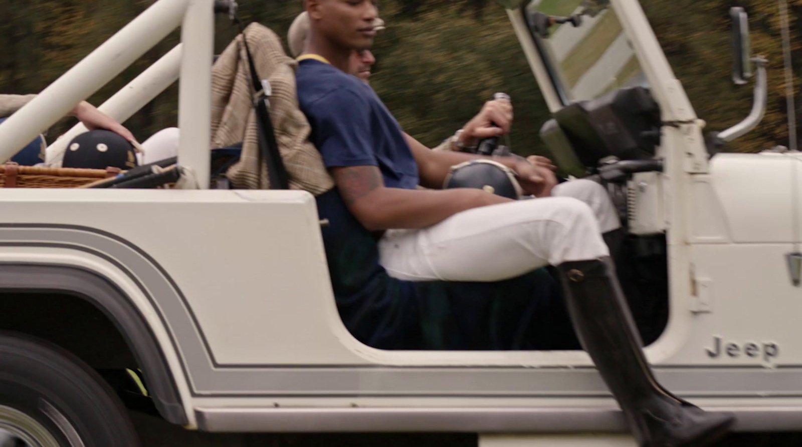 a man riding in the back of a white jeep