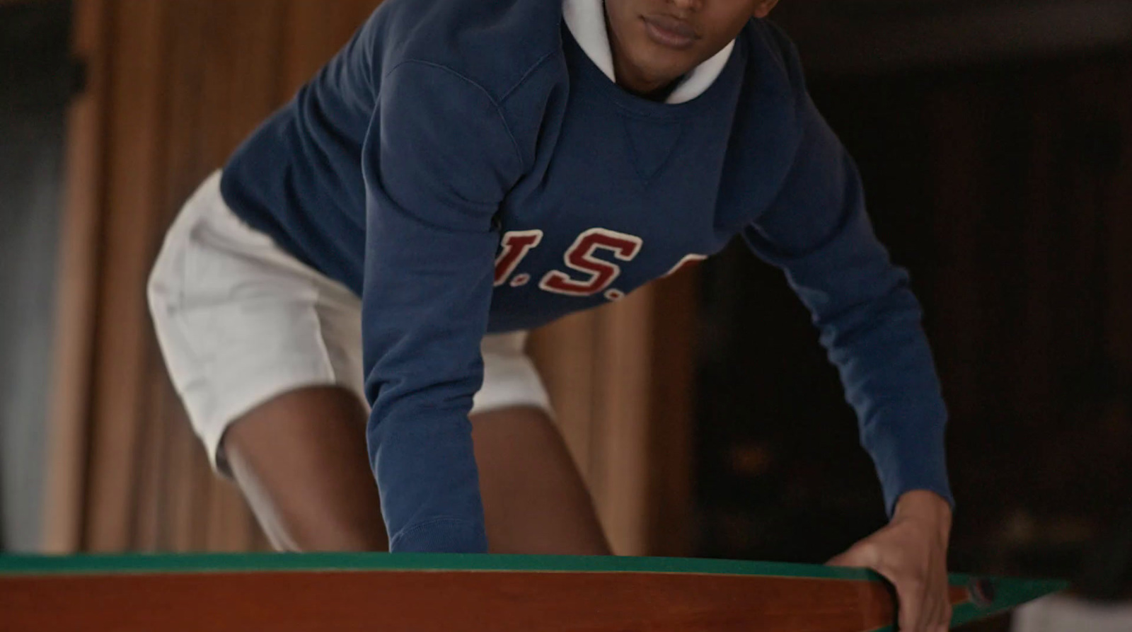 a young man leaning over a pool table