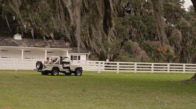 a jeep parked in front of a white barn