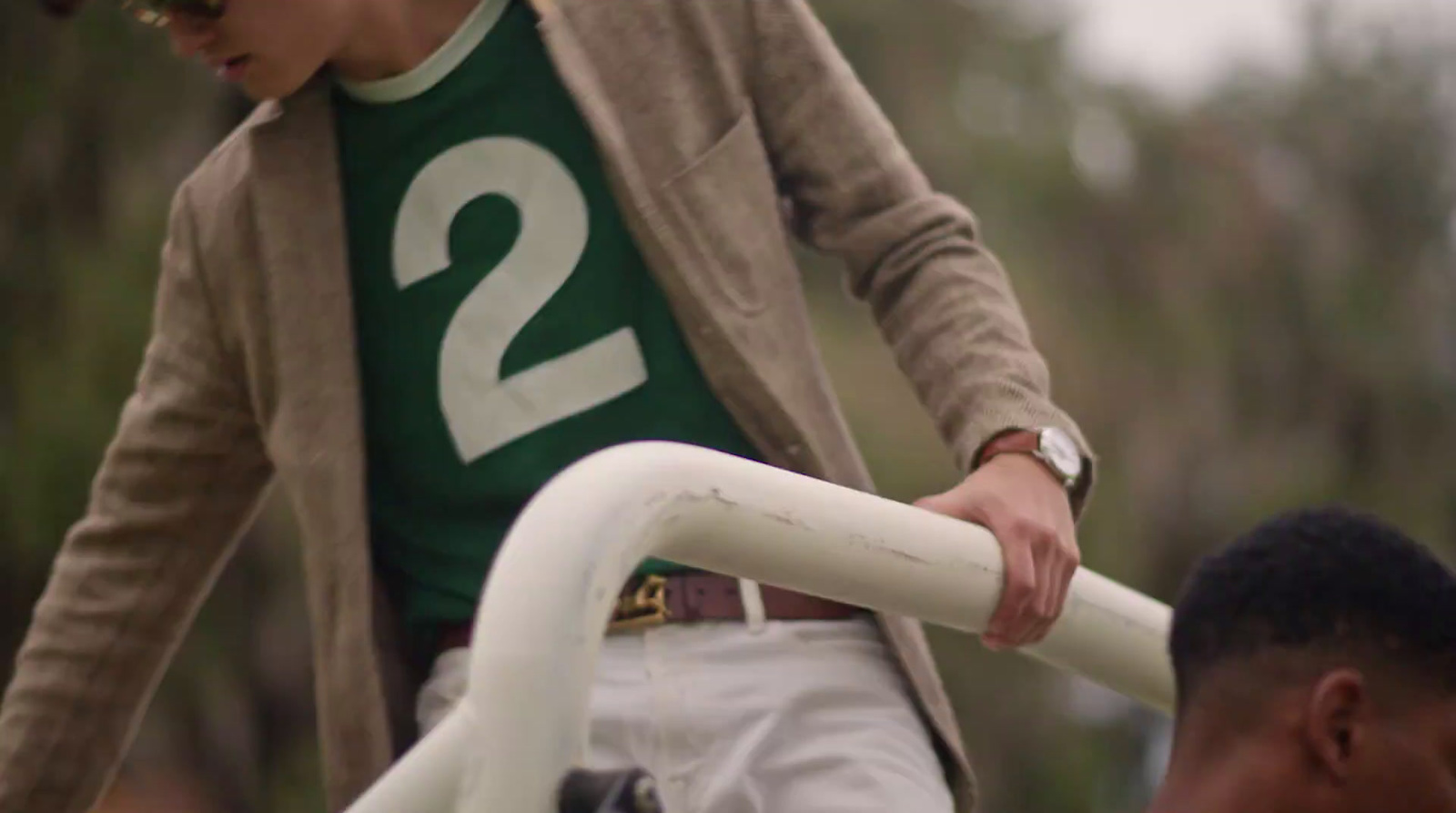 a man in a green shirt and white pants