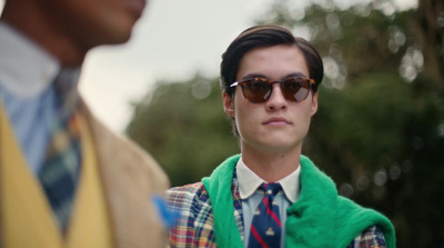 a man wearing sunglasses and a green vest