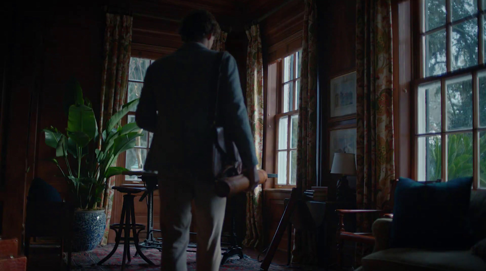 a man standing in front of a window in a living room