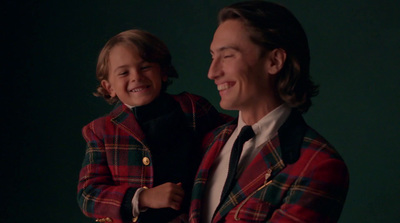 a man in a red and black jacket holding a child