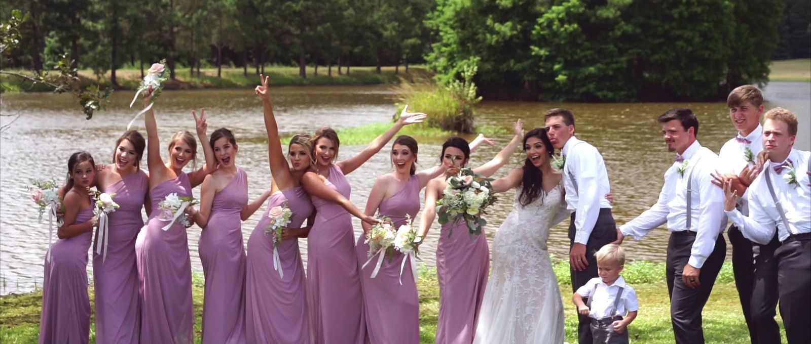 a group of people standing next to each other in front of a lake