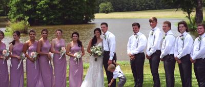 a group of people standing next to each other in front of a lake